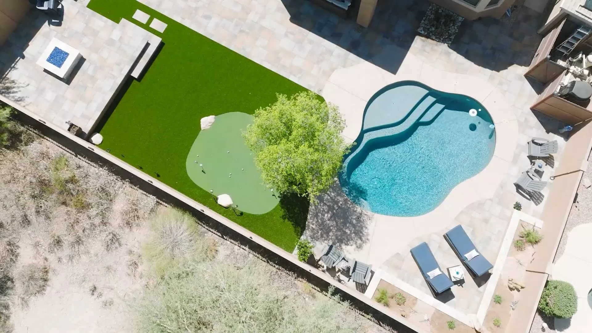 A large backyard transformation in Scottsdale, AZ showing landscape design around a freeform pool